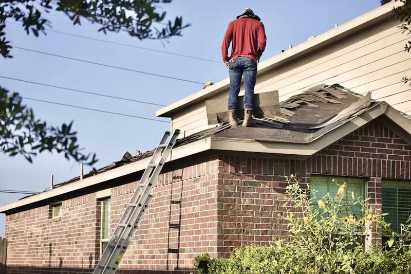 Professional roofer working on a residential roof in Towle